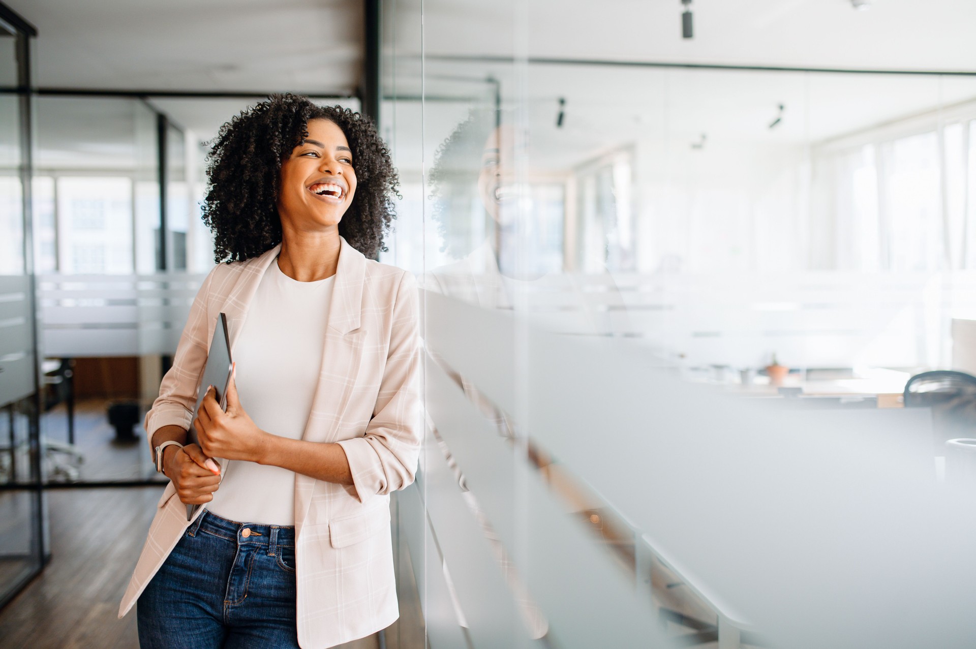 A young professional woman stands confidently in a modern office